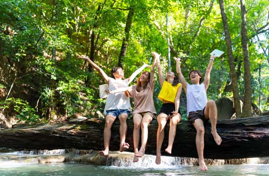 畢業旅行大自然秘境探險 坐在森林溪流巨木上開心歡呼